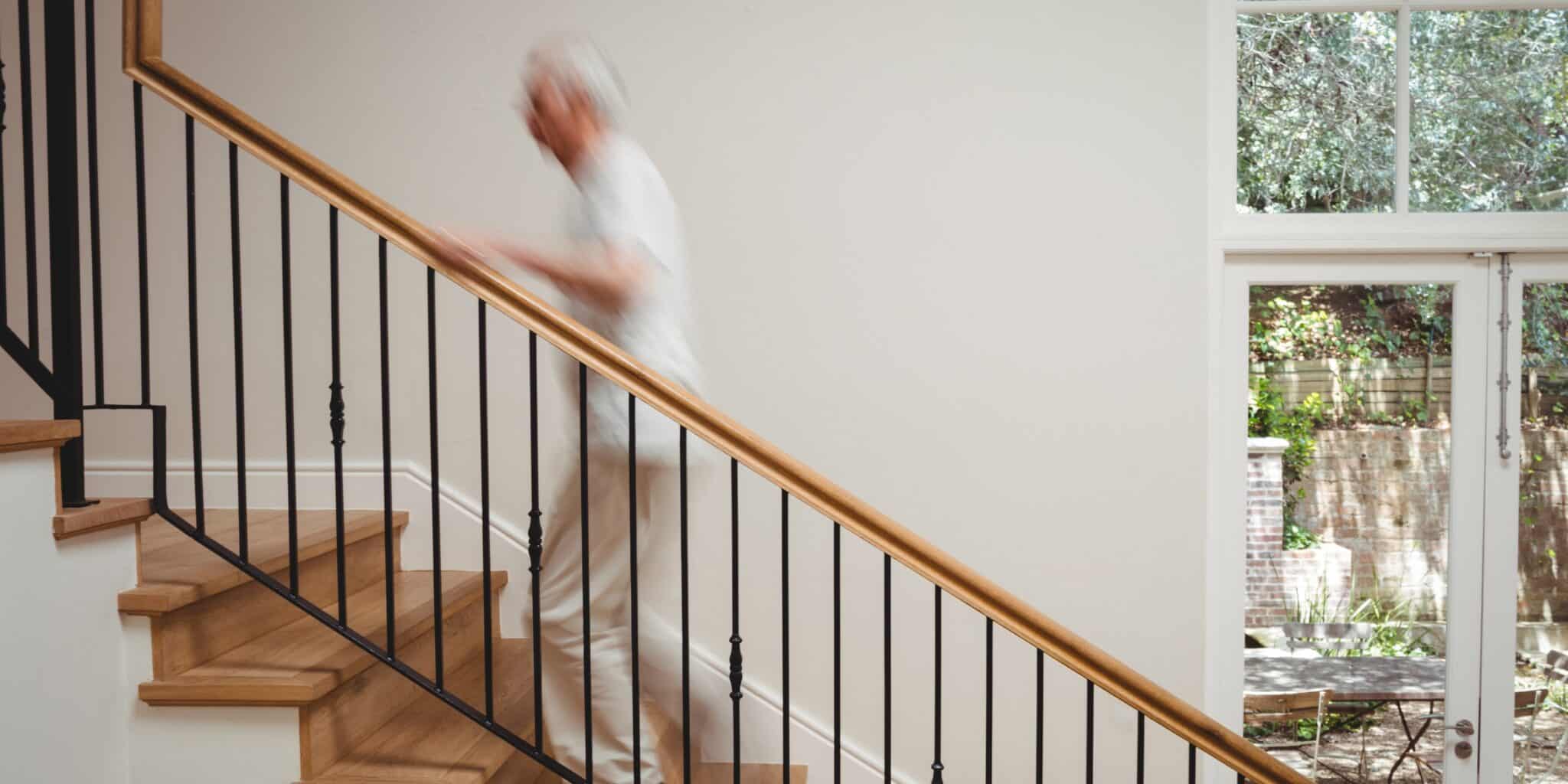 Une personne de plus de 60 ans monte un escalier